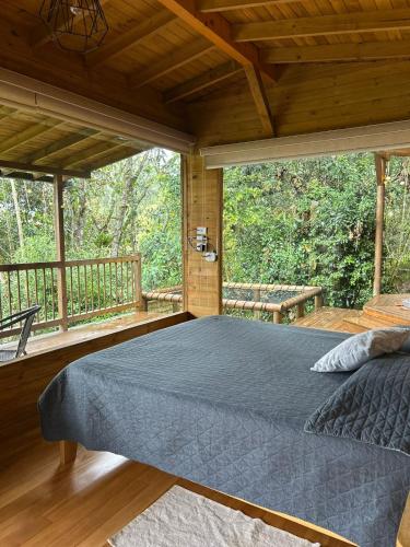 a bedroom with a large bed on a porch at MAGDA Nature Lodge in El Retiro