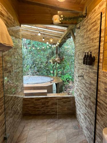 a bathroom with a glass shower with a tub at MAGDA Nature Lodge in El Retiro