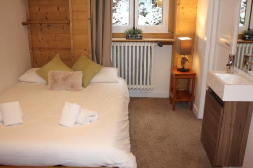 a bedroom with a white bed with a sink and a window at Les Campanules in Les Houches
