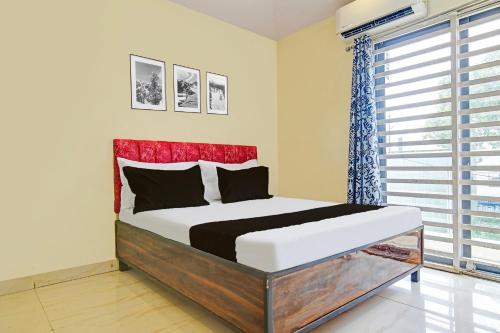 a bedroom with a large bed with a red headboard at Hotel O Paradise Green in Indore