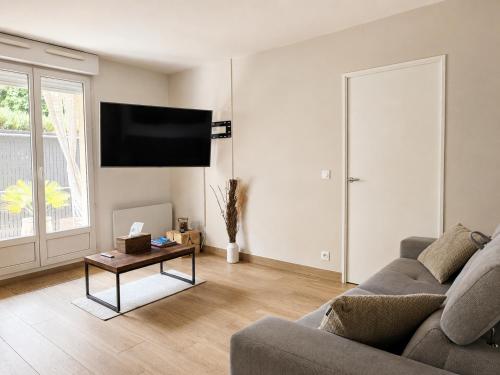 a living room with a couch and a table at Le splend'id à 10min de Disneyland in Chessy