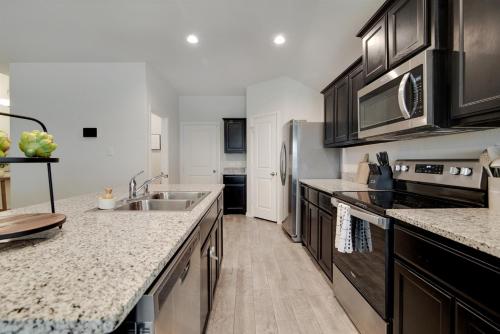 a kitchen with a sink and a refrigerator at A Serene Oasis! 4-bedrooms! in Saginaw