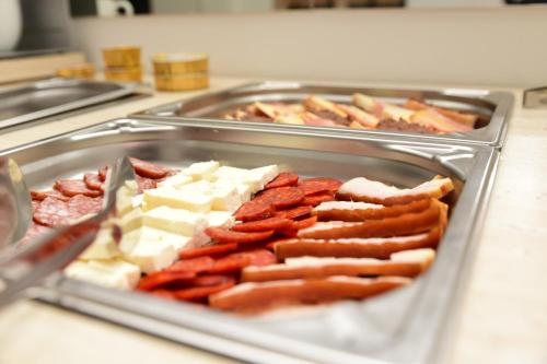 a tray of sausages and other foods on a counter at Hotel Alexis in Cluj-Napoca