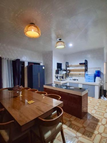 a kitchen with a wooden table and chairs at Nomads Retreat House in Moalboal