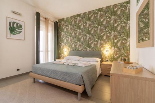 a bedroom with a bed with a tropical wallpaper at In Centro a Rho Fiera Milano e Ospedale Galeazzi in Rho