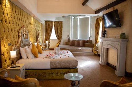 a bedroom with a king sized bed and a fireplace at The Dixie Dean Hotel in Liverpool
