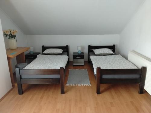two beds in a room with wooden floors at Nika in Ogulin