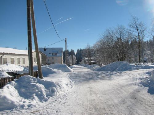 a snow covered street with snow piled up at Reiterhof & Pension Lienemann in Grünbach