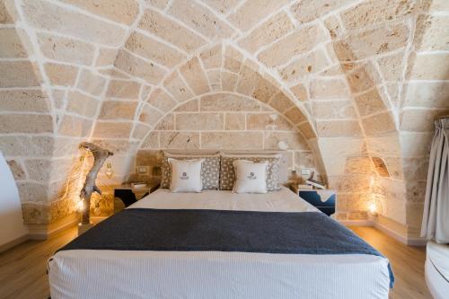 a bedroom with a large bed in a stone wall at Melodia del Salento - Lecce Selection in Surbo