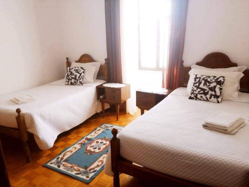 a bedroom with two beds and a window at Casa do Centro - Alojamento Local in Vieira do Minho