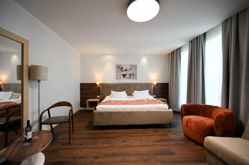 a hotel room with a bed and a chair at Boutique Hotel Ukus in Tešanj