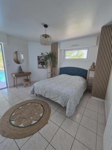 a bedroom with a bed and a table and a window at Villa La Digue in Plobsheim