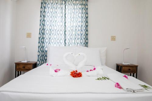 a white bed with a heart decoration on it at Neem View Apartments - Studio in Falmouth