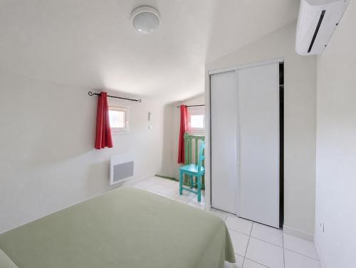 a bedroom with a bed and a sliding glass door at Cottage clim piscine in Saint-Saturnin-lès-Avignon