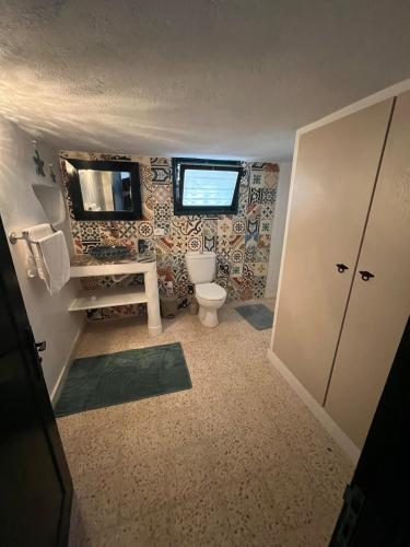 a bathroom with a toilet and a sink and a mirror at Villa Zina s3 in El Mây
