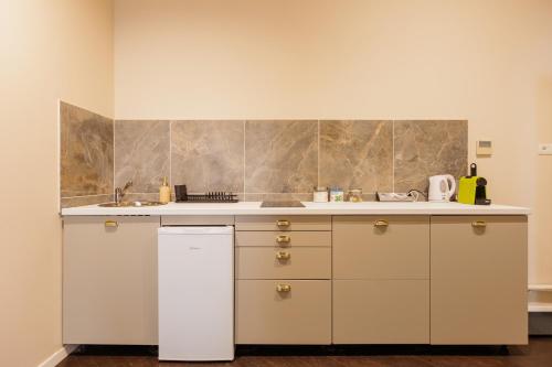 a kitchen with white cabinets and a sink at #Artistic Flat 2BR Historical Center Timișoara in Timişoara