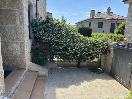 a garden with a bush next to a building at La Villa Allariz in Allariz