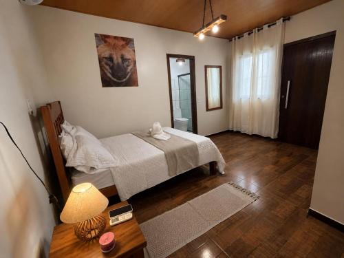 a bedroom with a bed and a table with a lamp at Pousada Refúgio Encantado-Cavernas do Peruaçu in Itacarambi