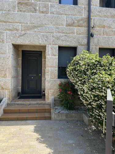 a black door on the side of a brick building at La Villa Allariz in Allariz