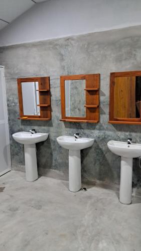 a bathroom with two sinks and mirrors on the wall at Holabay Surf Hostel in Arugam Bay