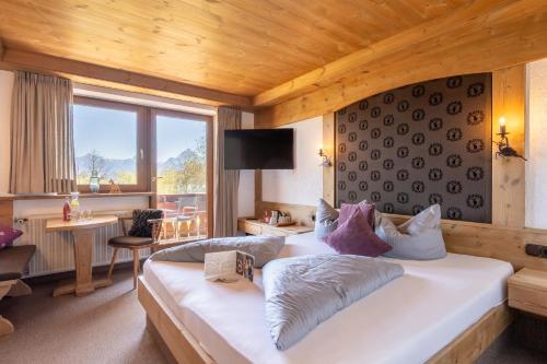 a bedroom with a large white bed in a room at Dreimäderlhaus - Das vegetarische Boutique Hotel in Füssen