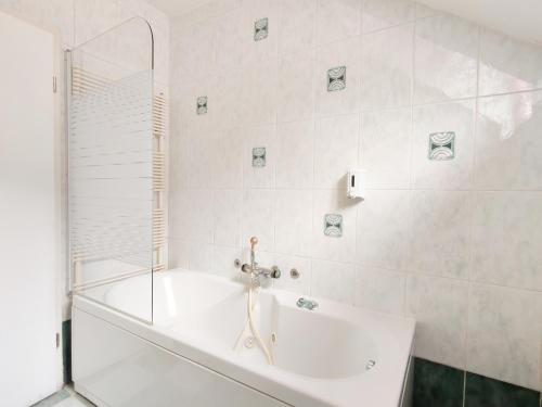 a white bathroom with a tub and a shower at Rooms Čehovin in Postojna