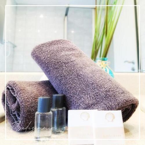 a purple towel sitting on top of a counter with cosmetics at Hotel am Markt in Bad Lobenstein