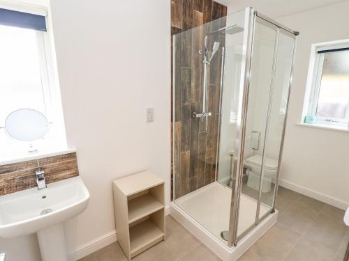 a bathroom with a shower and a sink at The Lilac Owl in Lincoln