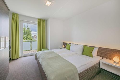 a bedroom with a large bed and a large window at Haus Ostseekristall Wohnung Rubin in Zinnowitz