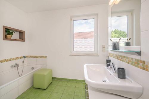 a white bathroom with a sink and a tub at Haus Ostseekristall Wohnung Rubin in Zinnowitz