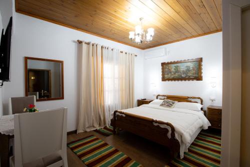 a bedroom with a bed and a wooden ceiling at Kashah Residence in Gjirokastër