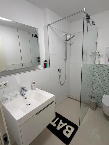 a white bathroom with a sink and a shower at Beautiful living in Schönaich