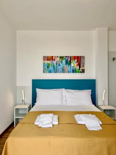 a bedroom with a large bed with two towels on it at Hotel Royal Garnì in Caorle