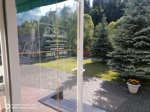 a sliding glass door with a sign in a yard at Chalet Zolota Pidkova&River 1 in Slavske