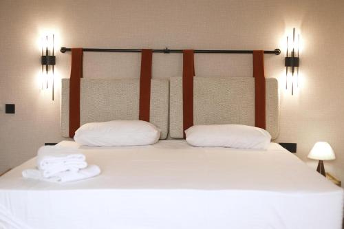 a bed with two pillows and two towels on it at Jetel Boutique Hotel in Almaty
