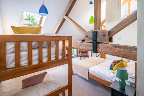 two bunk beds in a room with a attic at Wolmers Barn in Stonham Aspall