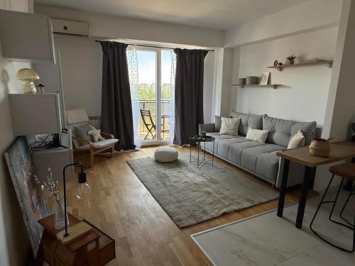a living room with a couch and a large window at City nest Skopje in Skopje