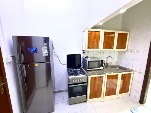 a kitchen with a refrigerator and a microwave at المرور ابو ظبي in Abu Dhabi