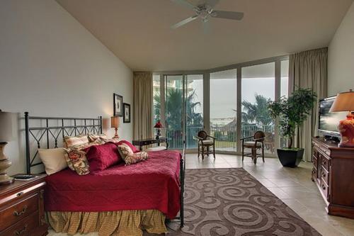 Caribe Resort Unit C101 في شاطئ أورانج: غرفة نوم بسرير وتلفزيون بشاشة مسطحة