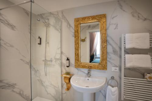 ein Badezimmer mit Waschbecken und Spiegel in der Unterkunft Morali Palace in Genua