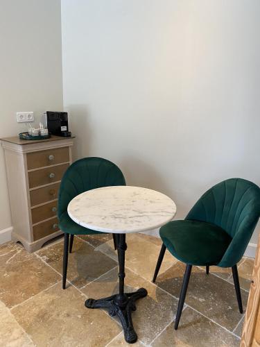 two green chairs and a table and a table and two chairs at La Félicité in Boissy-le-Sec