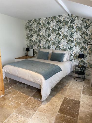a bedroom with a large bed with a floral wallpaper at La Félicité in Boissy-le-Sec