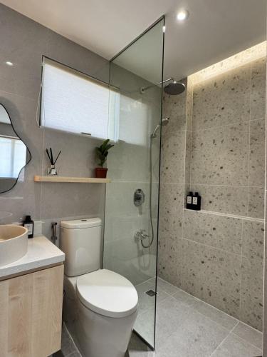 a bathroom with a toilet and a glass shower at J-Stays 2BR Beach Condo at Seafront Residences in San Juan