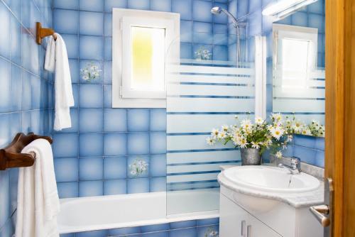 a blue tiled bathroom with a sink and a tub at Villa Roca Nova in Cacla D'or