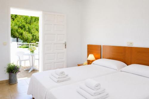 two beds in a white room with a window at Villa Roca Nova in Cacla D'or