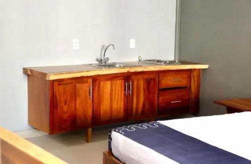 a kitchen with a sink and a bed in a room at Samanu Hotel & Suites in Sayulita