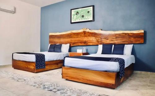 two beds in a bedroom with blue walls at Samanu Hotel & Suites in Sayulita