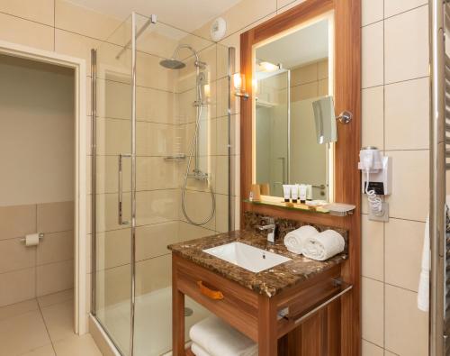 a bathroom with a sink and a shower at Hôtel Eden by Odalys in Arc 1800