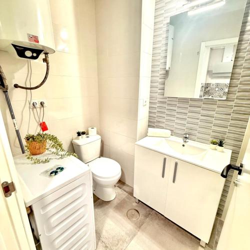 a bathroom with a toilet and a sink and a mirror at Hercules in Arroyo de la Miel