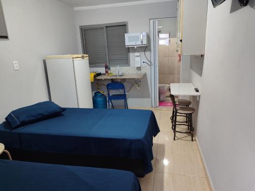 a small room with two beds and a kitchen at kitnet individual Campinas in Campinas